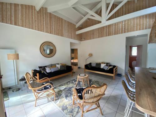 un salon avec des chaises, un canapé et une table dans l'établissement La Landaise au golf de Biscarosse, à Biscarrosse