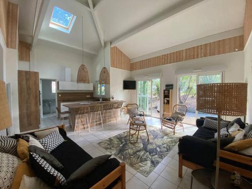 un salon avec un canapé et une cuisine dans l'établissement La Landaise au golf de Biscarosse, à Biscarrosse