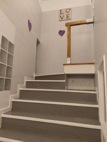 a staircase in a building with purple hearts on the wall at LA BELLE IVOIRE in Saint-Marcel