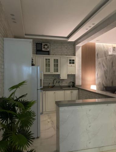 a kitchen with white cabinets and a refrigerator at شاليه خاص vip الشقيق-الدرب in Ash Shuqayq