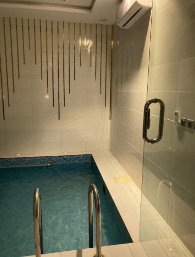 baño con piscina y ducha en شاليه خاص vip الشقيق-الدرب, en Ash Shuqayq