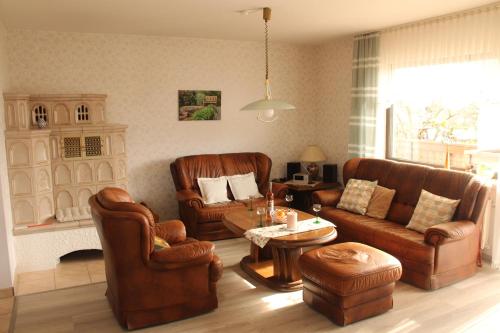 a living room with leather furniture and a table at Ferienwohnung Mietzner in Laubach