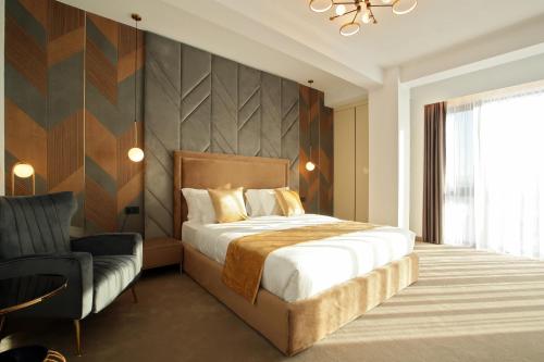 1 dormitorio con 1 cama grande y 1 silla en Hotel Artemis en Oradea