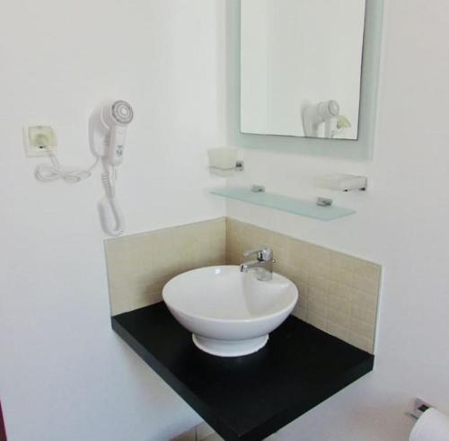 a bathroom with a white sink and a mirror at Coastal Comfort at Tortuga Beach - 292 in Prainha