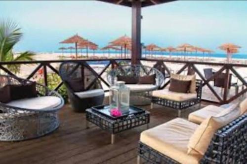 a patio with chairs and tables on the beach at Coastal Comfort at Tortuga Beach - 292 in Prainha