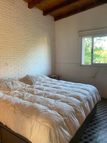 a large white bed in a room with a window at Casa Falda del Carmen in Santa María