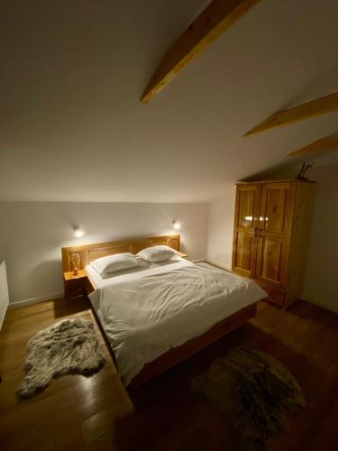 a bedroom with a large bed with white sheets at Hirsch Chalet Apuseni in Mărgău