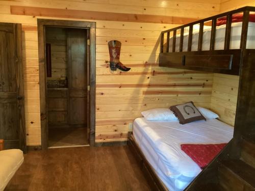 ein Schlafzimmer mit einem Bett in einem Blockhaus in der Unterkunft Dulce Vida in Concan