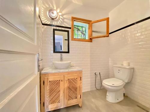 a bathroom with a white toilet and a sink at Dar Brahim, Cap Zbib , Vue sur mer in Al Matlīn
