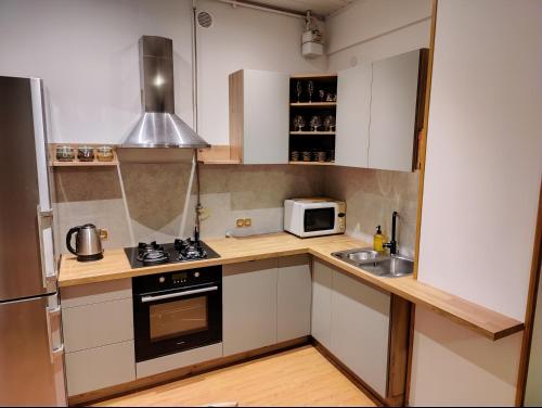 a small kitchen with a stove and a microwave at Spacious apartment near old town in Vilnius
