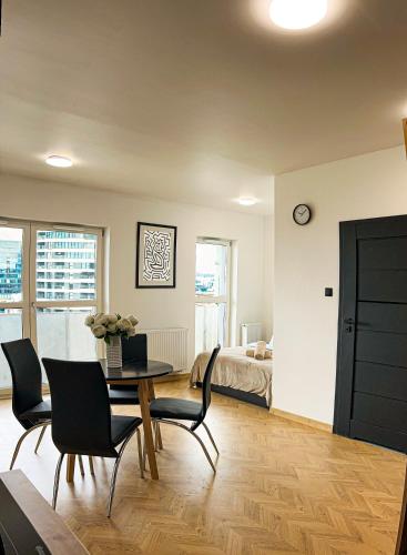 a living room with a table and chairs and a bedroom at Apartament Renard in Rzeszów