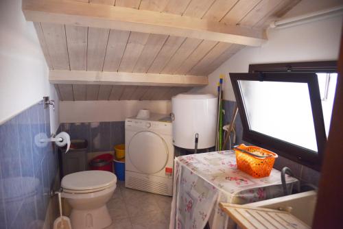 a small bathroom with a toilet and a table at Casa Vacanze Maria Antonietta in Vittoria