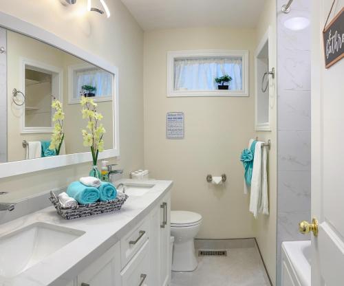 a white bathroom with a sink and a toilet at Newly-renovated 3BR house, 12 minutes to Airport in Toronto