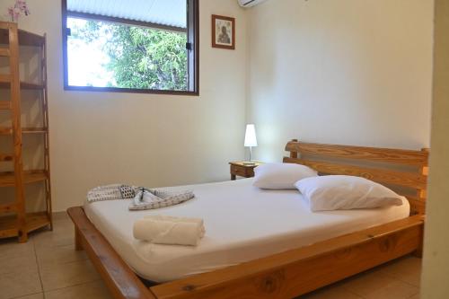 a bedroom with a large bed with a window at Villa Ti'Mangue Julie in Rémire-Camp