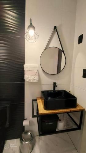 Un baño con un lavabo negro y un espejo. en Recanto dos pássaros, en Garibaldi