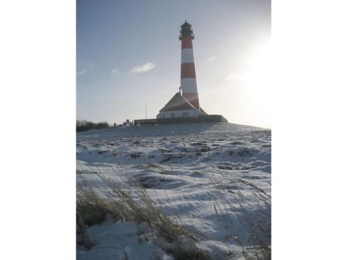 a lighthouse on the beach with snow on the ground at Holiday apartment Leah in Tönning