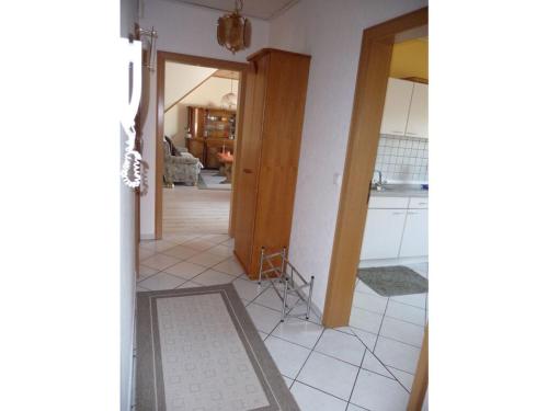 a room with a tile floor and a hallway with a door at Holiday apartment Moorwiese in Bergeshövede