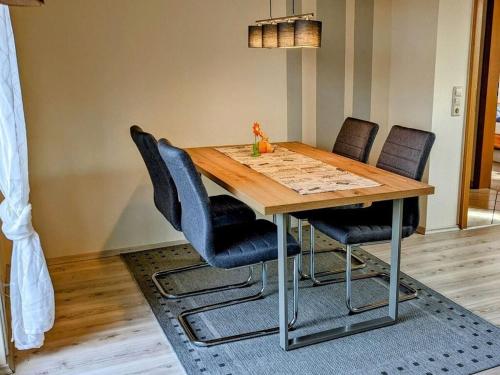 a dining room table with four chairs around it at Holiday apartment Moorwiese in Bergeshövede