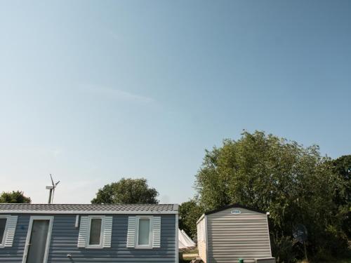 a house and a shed with trees in the background at Campingplatz Johannisberg in Fehmarn