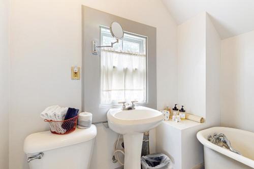 een badkamer met een wastafel, een toilet en een spiegel bij Fort Casey Inn Cottage 1 in Coupeville