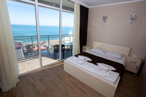 Habitación de hotel con cama y ventana grande en SeaGate en Batumi