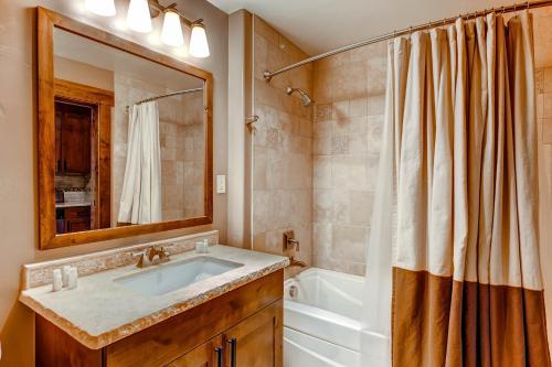 a bathroom with a sink and a tub and a shower at Trailhead Lodge in Steamboat Springs