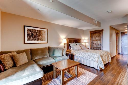 a living room with a couch and a bed at Trailhead Lodge in Steamboat Springs