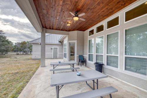 a porch with two picnic tables and a ceiling fan at Driftwood in Concan