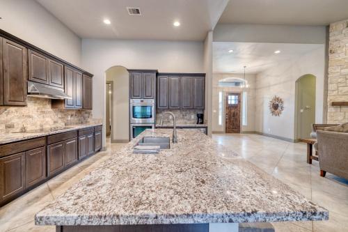 a large kitchen with a large marble counter top at Driftwood in Concan