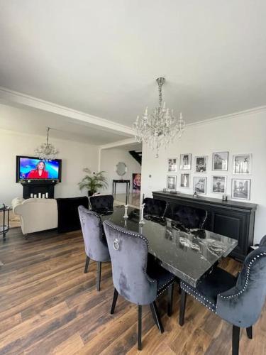 Duke’s House في بيستريتسا: غرفة طعام مع طاولة وكراسي وغرفة معيشة