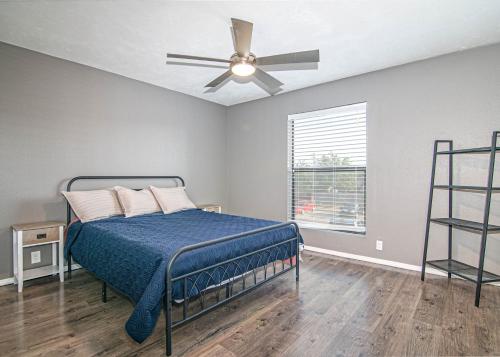 a bedroom with a bed with a ceiling fan at Midland Condo With Pool in Midland