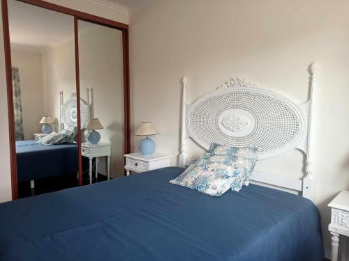 a bedroom with a blue bed and a mirror at Moradia da Bananeira in Lagoa de Albufeira