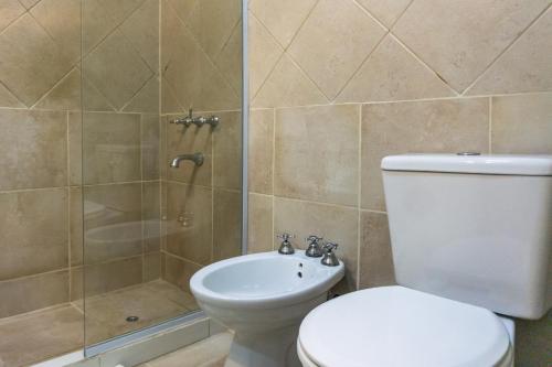 een badkamer met een toilet en een douche bij Gente del Sur - Gobernador Paz in Ushuaia