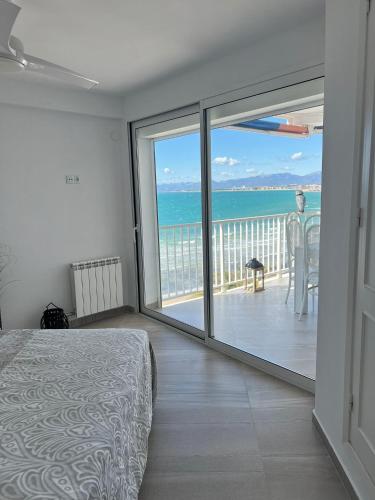 a bedroom with a bed and a view of the ocean at Bello Horizonte Apartman 4B in Salou