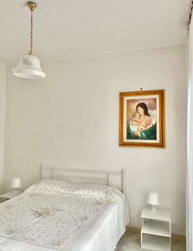 a bedroom with a bed with a painting on the wall at Seafront View in Mola di Bari