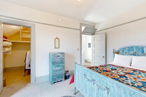 - une chambre avec un lit bleu et une commode dans l'établissement Fort Casey Inn Cottage 7, à Coupeville