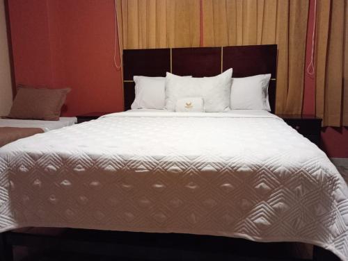 a large bed with a white comforter and pillows at Madison Suite in Tacna