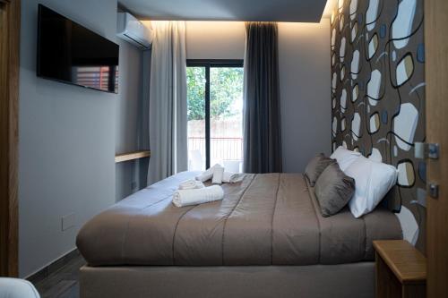 a bedroom with a large bed with a window at La Scogliera In in Aci Castello