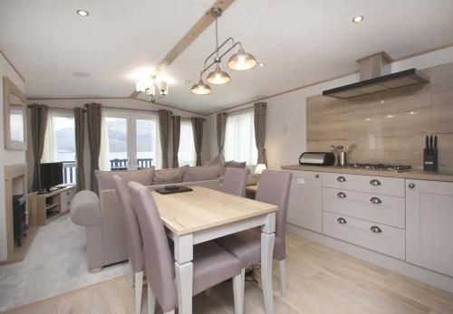 a kitchen and dining room with a table and chairs at Loch Lomond Holiday Park in Inversnaid