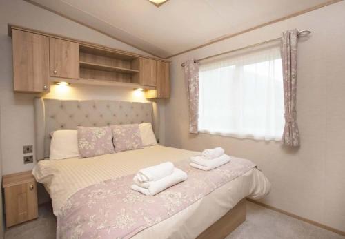 a bedroom with a bed with two towels on it at Loch Lomond Holiday Park in Inversnaid