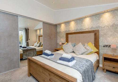 a bedroom with a large bed with towels on it at Loch Lomond Holiday Park in Inversnaid