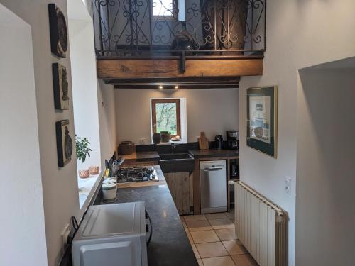 a kitchen with a sink and a balcony at Manoir du Boscau, Louis IX in Prudhomat