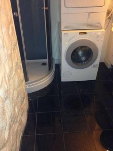 a washing machine in a bathroom with a washer at A Double Room - Not a complete apartment - Perfect Location for exploring the City by walking in Bergen