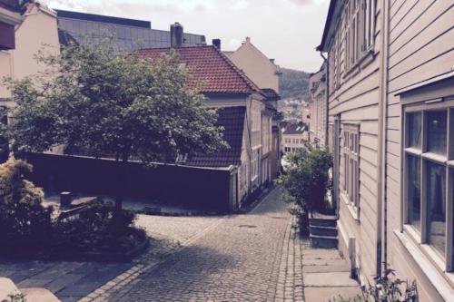 un callejón en una ciudad con edificios y un árbol en A Double Room - Not a complete apartment - Perfect Location for exploring the City by walking, en Bergen