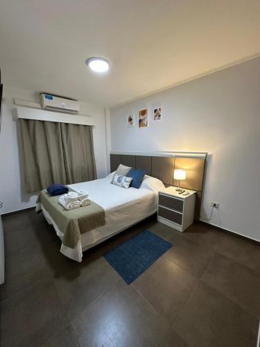 a bedroom with a large bed and a nightstand and a bed sidx sidx sidx at SOMBRAS DEL PARANA Apart Misiones in Eldorado