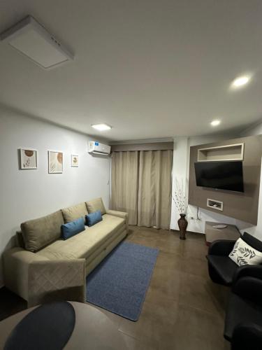 a living room with a couch and a tv at SOMBRAS DEL PARANA Apart Misiones in Eldorado