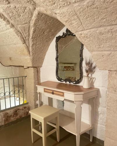 a dressing table with a mirror and a stool at La Ramasola in Fasano