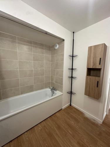La salle de bains est pourvue d'une baignoire blanche et de parquet. dans l'établissement Appartement pierrefitte, à Pierrefitte-sur-Seine