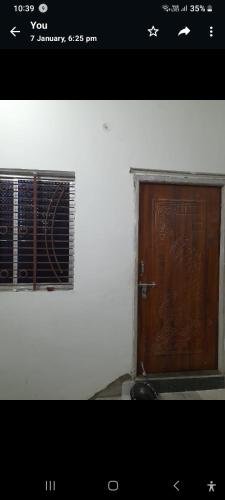 a picture of a wooden door with a window at Gunjan Cottage in Deoghar