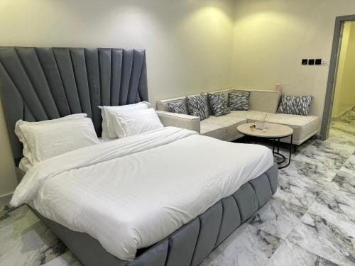 a bedroom with a large bed and a couch at أستديو بدخول ذكي حي الربوة in Riyadh